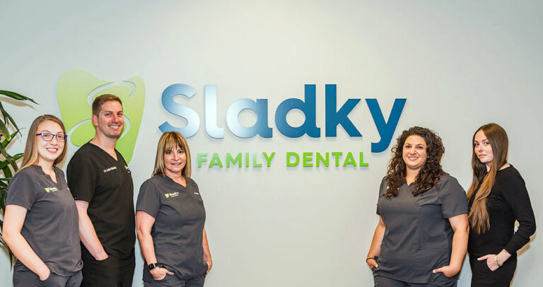 team members standing around office sign